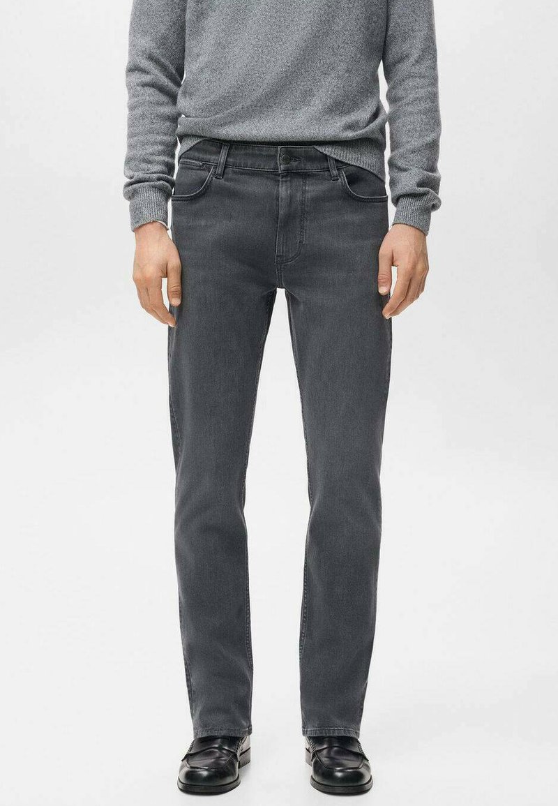 Vaqueros de mezclilla gris con corte de pierna recta, diseño de cinco bolsillos y sutil desgaste. Combinados con un suéter gris texturizado y zapatos negros.