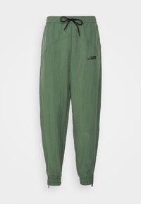 Lekka zielona spodnie dresowe z elastycznym pasem, sznurkiem do regulacji, bocznymi kieszeniami i elastycznymi mankietami; posiadają małe czarne logo.