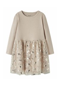 Robe à manches longues avec haut beige côtelé et jupe en tulle scintillante ornée de motifs de nœuds métalliques. Matière douce avec design en couches.