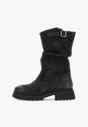 Czarne skórzane botki do kostki z grubą podeszwą i srebrnym paskiem z klamrą w górnej części, pokazane z boku na białym tle.