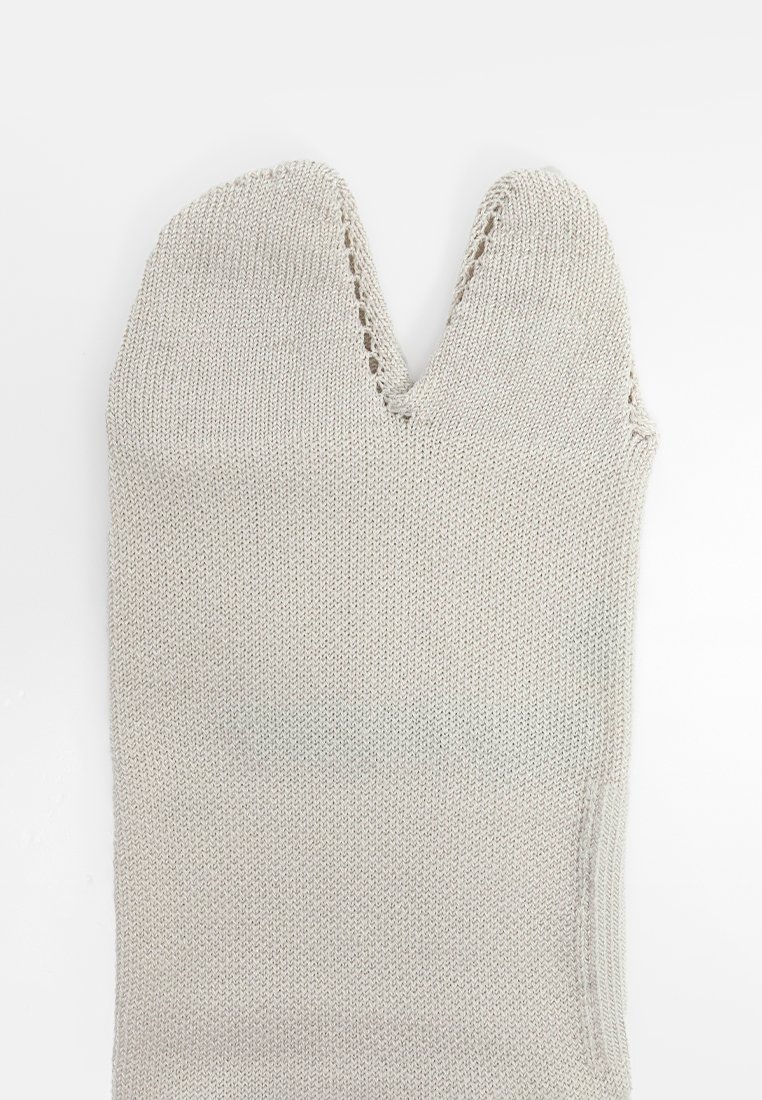 Mitaine tricotée gris clair avec une ouverture en forme de V en haut. Présente une couture fermée et un tissu texturé pour une meilleure adhérence. Sans ornements.