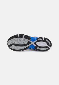 A sola do sapato atlético azul apresenta um padrão texturizado com acentos em borracha preta e seções em cinza na entressola para tração e suporte.