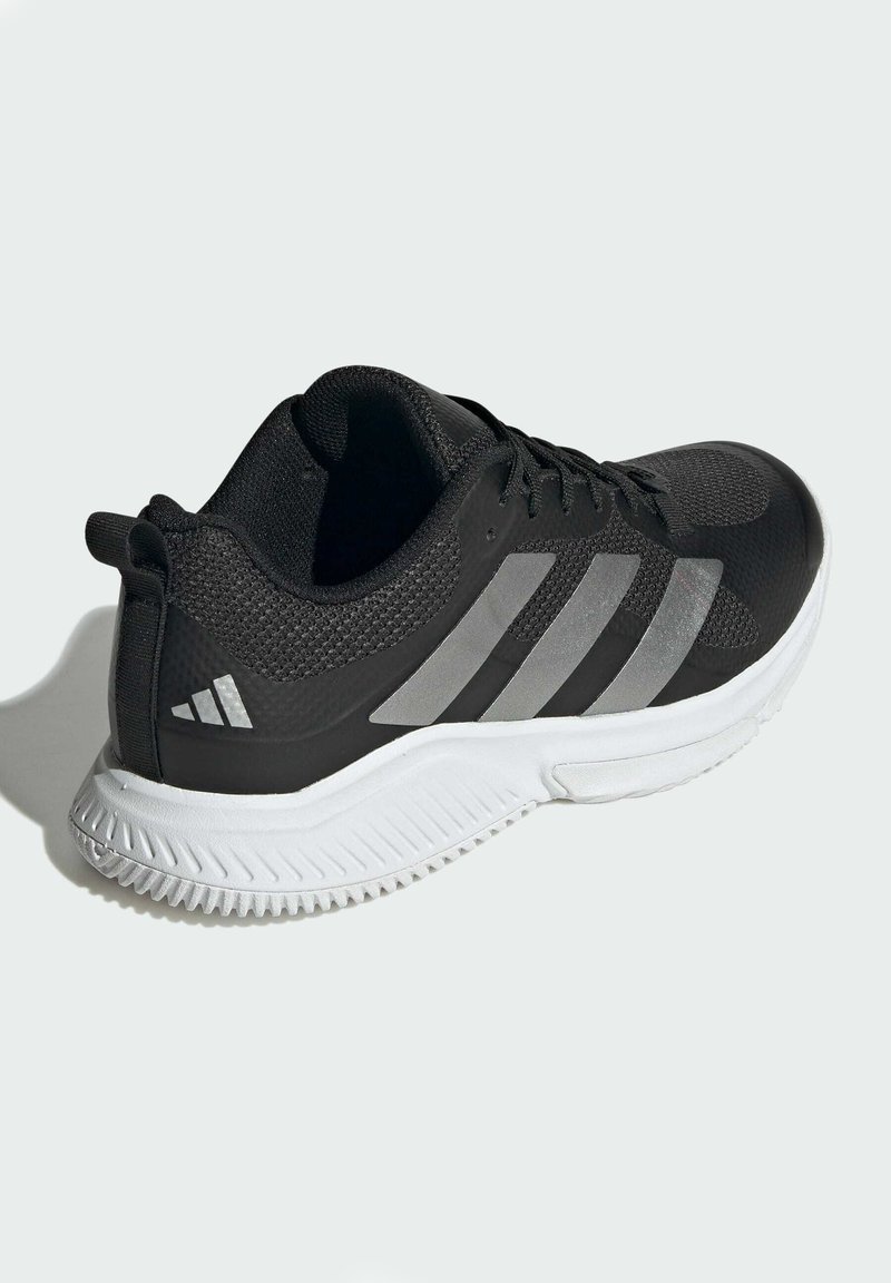 Bottillon de sport noir avec une tige en mesh texturé, trois rayures argentées et une semelle extérieure en caoutchouc blanc avec un motif de traction.