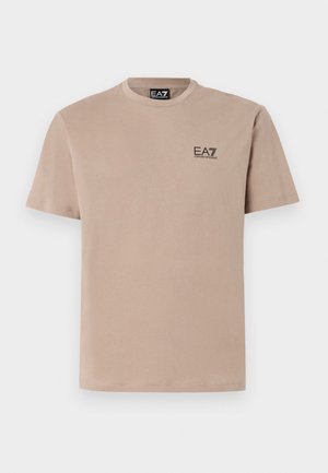 T-shirt beige a girocollo realizzato in cotone morbido, caratterizzato da un piccolo logo EA7 nero sul lato sinistro del petto e maniche corte.