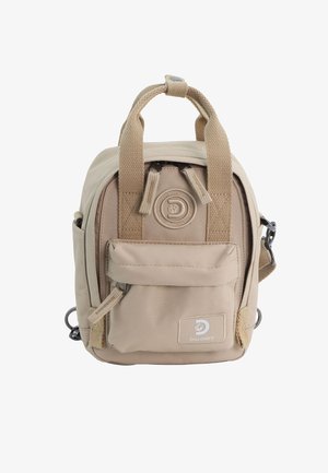 Beiger Canvas-Rucksack mit zwei oberen Griffen, Vordertasche und seitlichen Schlaufen. Reißverschluss mit Logo-Label und strukturierten Stoffdetails.