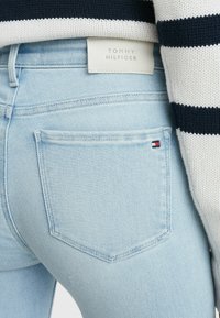 Světle modré džíny s rovnim střihem, s logem značky Tom Hilfiger a malou značkou u zadní kapsy. Strukturovaná látka.