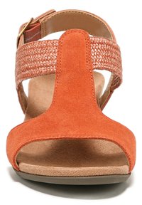 Orange suede sandal with a woven strap, open toe, and a cushioned footbed. Features a flat sole and adjustable ankle buckle.