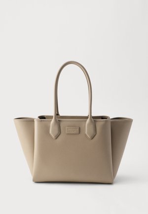 Beige structured tote bag with two handles, smooth texture, and wide side panels expanding outward on a plain white background.