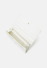 White leather wallet with a folded design. Features a snap closure, multiple card slots, and a zippered compartment for coins.