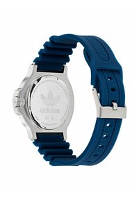 Adidas pulkstenis ar nerūsējošā tērauda korpusu un teksturētu zilu silikona siksniņu. Tam ir sudraba aizmugure ar Adidas logo un ūdensizturība.