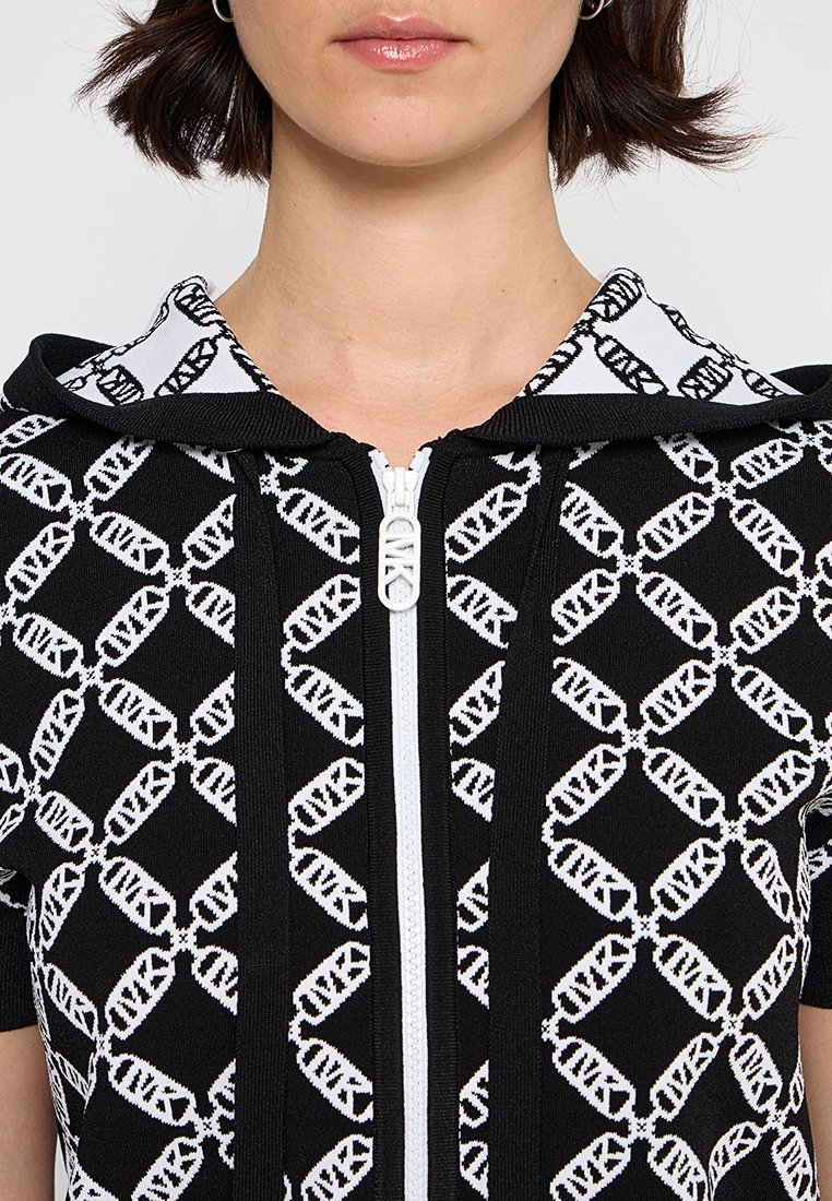 Zwarte ritshoodie met een patroon in wit. Inclusief een capuchon en contrasterende witte rits, gemaakt van een textuurstof.