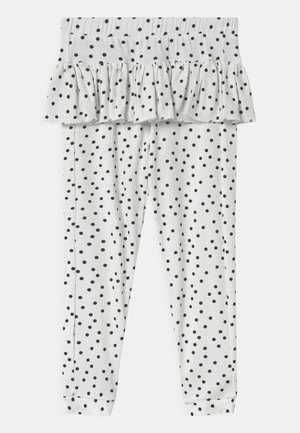 Bílé dětské legíny s černými puntíky a volánkovou sukní připevněnou na pase.