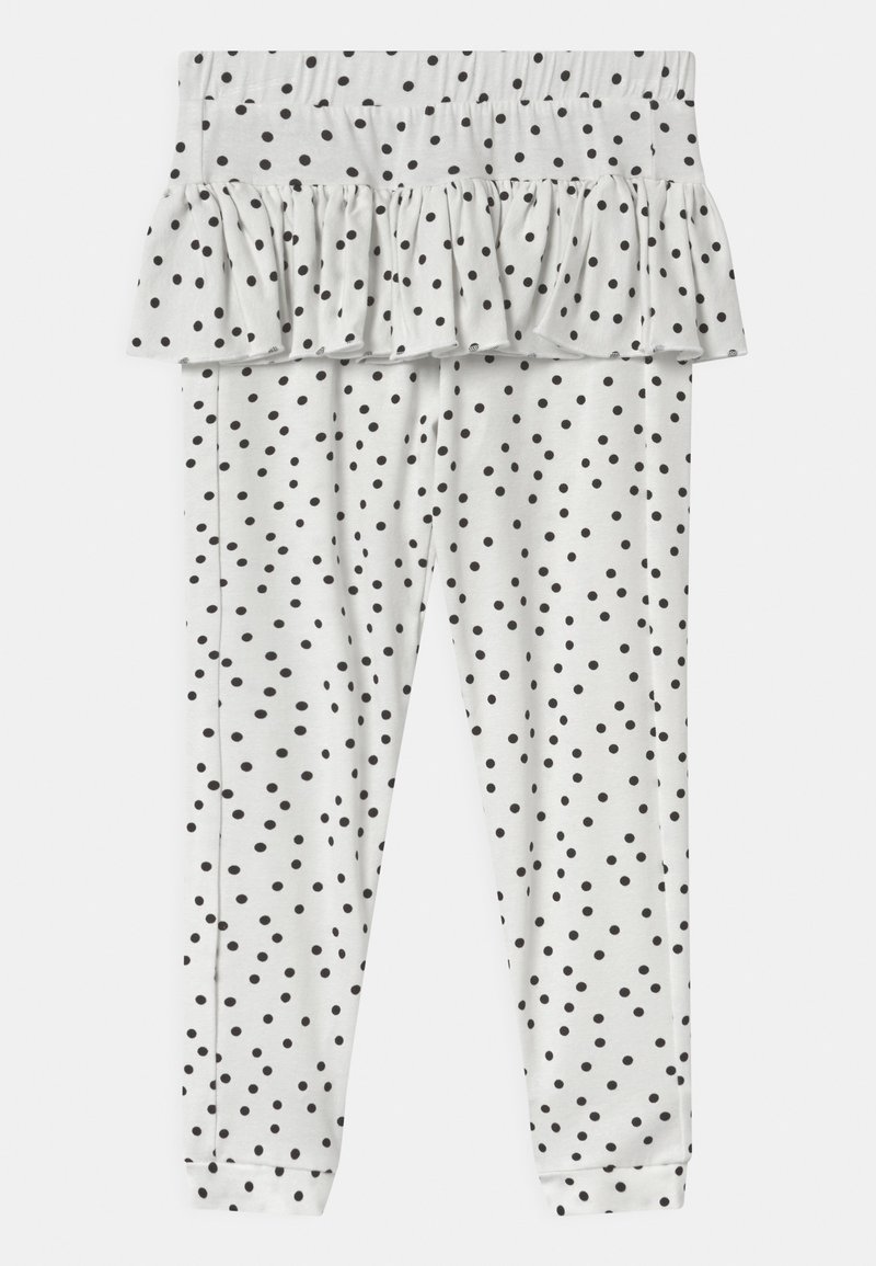 Białe legginsy dla niemowląt w czarne kropki, z przymocowaną falbaną na pasku.