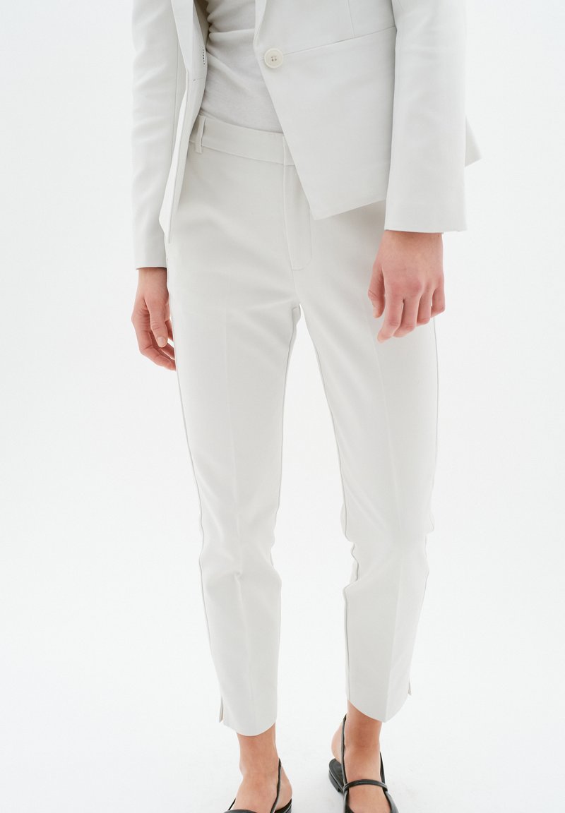 Op maat gemaakte witte broek met een slim fit, met een middelhoge taille, lichte zijsplitten aan de zoom en een gladde stofstructuur.