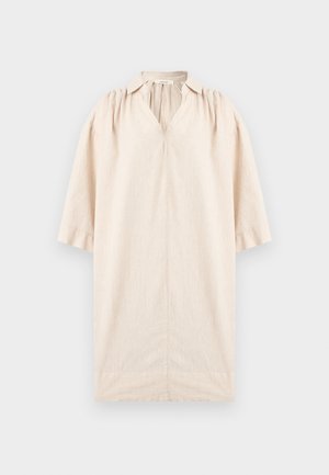 Robe beige longueur genou avec col en V, manches trois-quarts et détails froncés à l'épaule, présentée sur un fond uni.