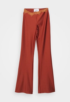 Pantalons évasés de couleur rouille profonde avec une finition brillante et un détail de ceinture en dentelle élaborée. Le matériau est lisse et extensible.