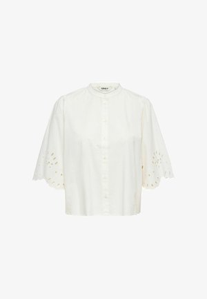 Biała bluzka z krótkim rękawem, z przodu zapinana na guziki, z okrągłym kołnierzykiem i falistą koronkową lamówką z oczkami na rękawach.