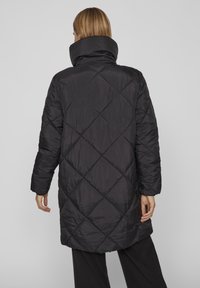 Črna prešita puf jakna z visokim ovratnikom, z diamond vzorcem, dolgimi rokavi in srednje dolgim krojem. Gladek, lahek material.