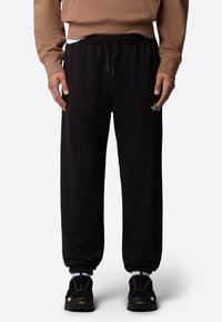 Zwarte sweatpants van zacht materiaal, met een elastische tailleband met trekkoord, geribbelde enkels en een klein logo-detail aan de zijkant.