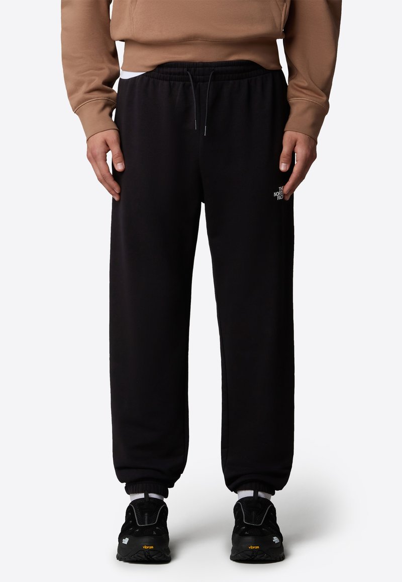 Zwarte sweatpants van zacht materiaal, met een elastische tailleband met trekkoord, geribbelde enkels en een klein logo-detail aan de zijkant.