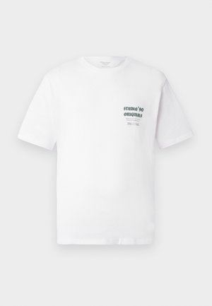Camiseta blanca de manga corta con pequeño texto negro "Studio '90 Originals" y texto adicional más pequeño en el lado izquierdo del pecho.