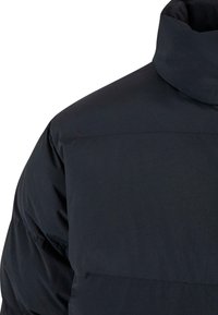 Jachetă puf din neopren neagră, cu guler înalt, material neted, cusături orizontale și un design ușor, izolat. Fără accesorii sau elemente de fixare vizibile.