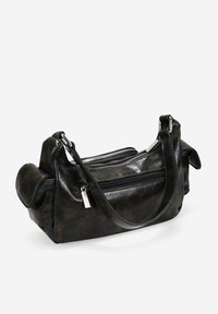 Bolso de mano de cuero negro y texturizado con dos compartimentos con cremallera y una correa corta. Presenta bordes redondeados y una silueta suave y estructurada.