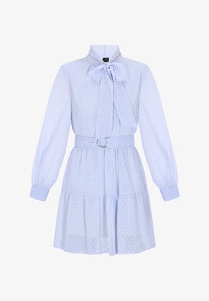 Helesinine kleit, millel on täppidega tekstuur, kõrge kaelus, pikad varrukad ja lips. Kätkeb vöökoht, millel on hõbedane rõngasdetail.