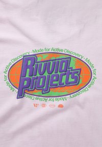 Lys rosa bomulls-T-skjorte med en stor, flerfarget grafikk med "Rivvia Projects", grønne og oransje detaljer, og et globusdesign.