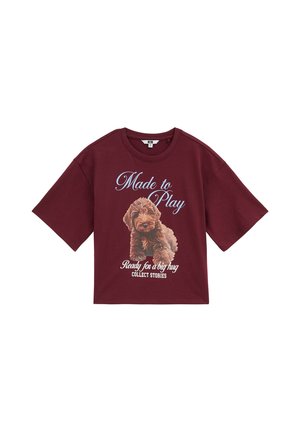 Dunkelrotes Kurzarmshirt mit einem Welpengrafik und dem Text "Made to Play" und "Ready for a big hug Collect Stories."