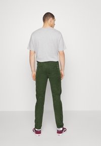 Levi's® XX CHINO SLIM TAPER PANTS - Chinos - mossy green 14w cord gd
