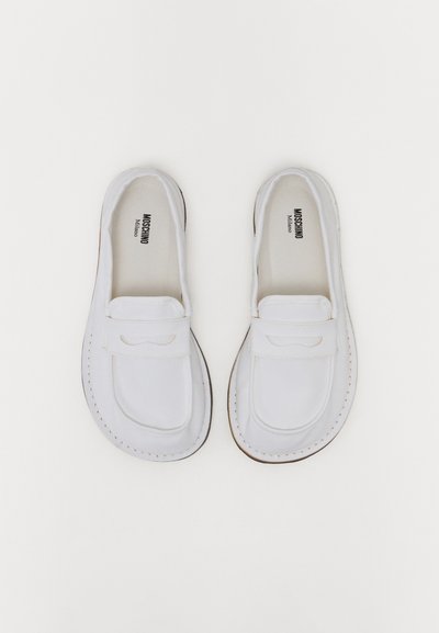 Hvide lærredssneakers med rund tå, syede detaljer og en lille accent på overdelen. Blødt interiør og flad gummisål.