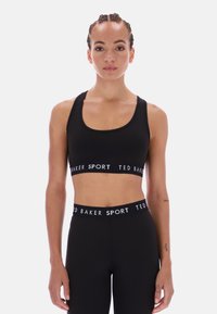 Crna sportska grudnjak napravljen od rastezljivog materijala, s izrezom u obliku šalice i 'TED BAKER SPORT' oznakom na elastičnoj traci. Jednostavan dizajn.