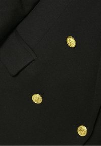 Svart kappa med guldfärgade dekorativa knappar, en strukturerad krage och en mjuk textur, designad med en skräddarsydd passform och klassisk silhuett.