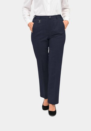Marineblauwe pantalons met een rechte pasvorm, voorzakken en een metalen accentdetail op de taille, gecombineerd met zwarte schoenen.