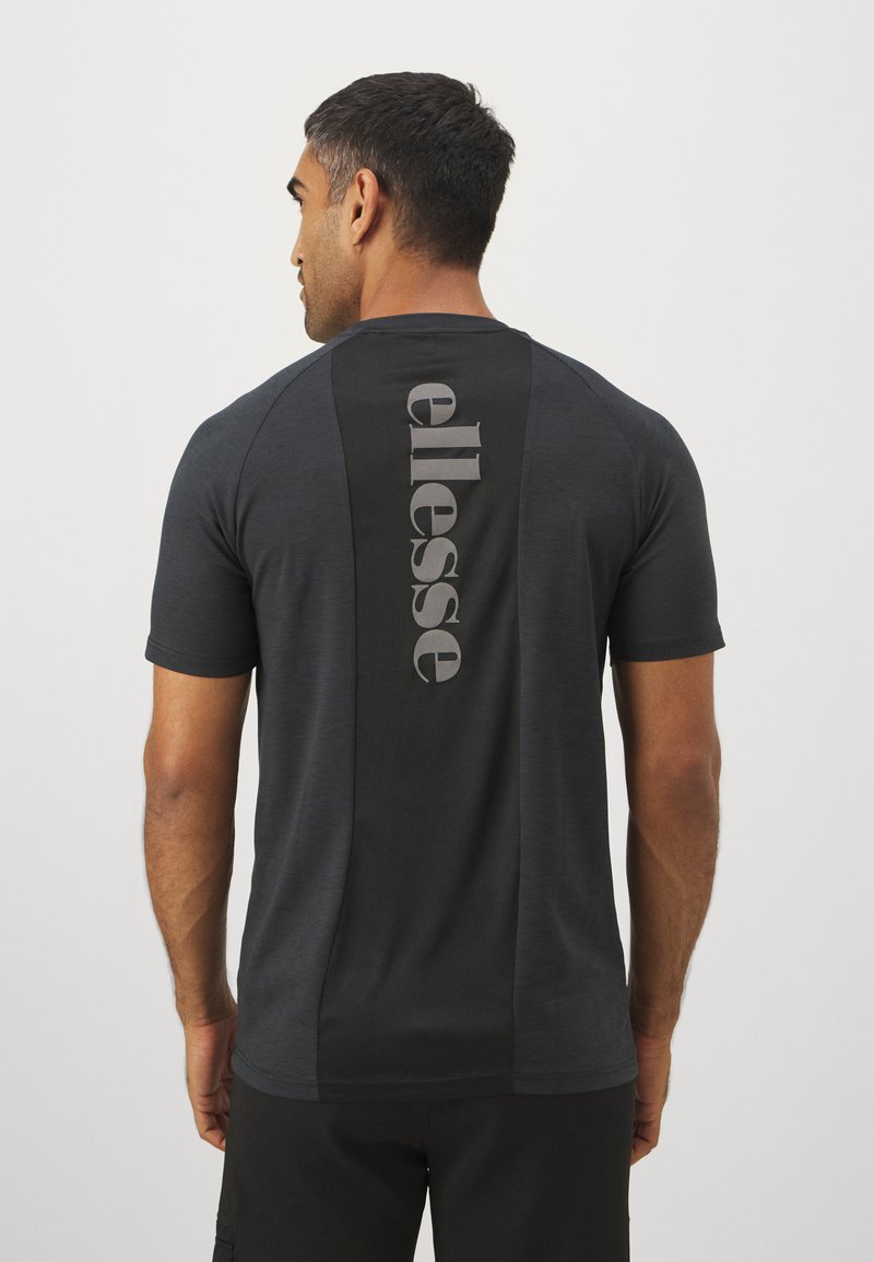 Schwarzes T-Shirt mit kurzen Ärmeln, das auf der Rückseite ein auffälliges graues "ellesse"-Logo vertikal zeigt. Es besteht aus einem glatten, leichten Stoff mit kontrastierenden Paneelen.