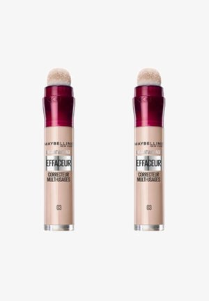 Deux tubes de correcteur Maybelline, beige clair avec une finition brillante, dotés d'un applicateur en éponge arrondi et d'un capuchon bordeaux. L'étiquette indique "03".