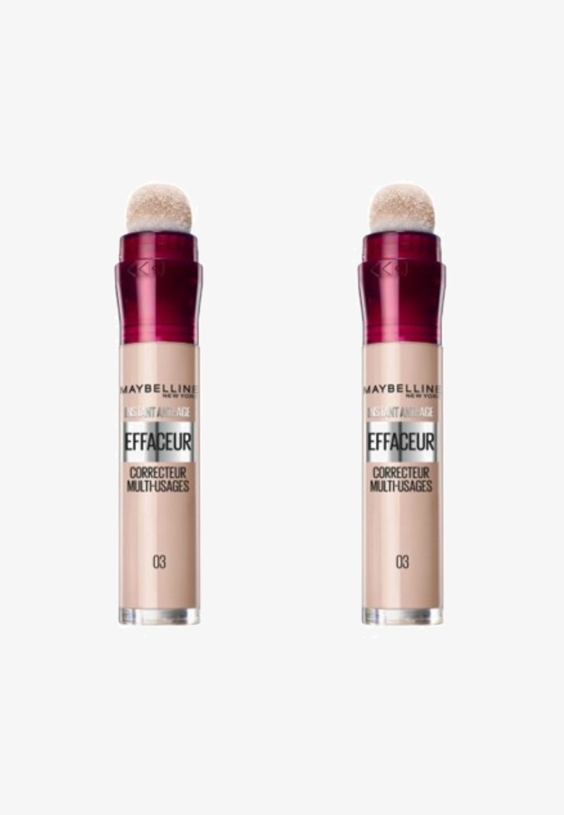Deux tubes de correcteur Maybelline, beige clair avec une finition brillante, dotés d'un applicateur en éponge arrondi et d'un capuchon bordeaux. L'étiquette indique "03".