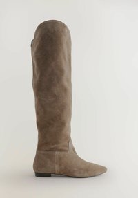 Bota de ante marrón hasta la rodilla con punta afilada y suela plana; presenta costuras sutiles a lo largo de la costura y una textura suave.