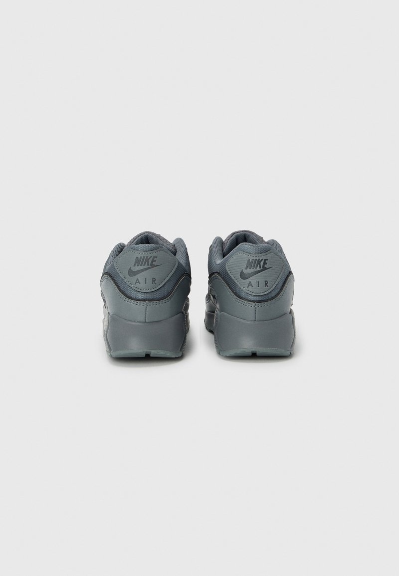 Gray Nike Air sneakers featuring a textured upper, padded collar, and heel logo. The sole is streamlined with a slight curve.