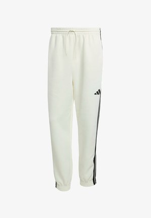 Valkoiset Adidas-housut mustilla sivu-urilla, joustava vyötärö nauhalla sekä joustavat hihnat nilkoissa.