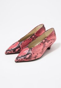 Tacones con estampado de serpiente en rosa y negro, con punta afilada y un pequeño tacón redondeado. Textura suave con un acabado brillante.