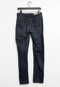 Mörkblå denimjeans med slim fit, som har två bakfickor med kontrastsömmar och en läderetikett vid midjebandet.