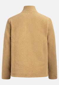 Beige fleecejakke med en teksturert overflate, høy krage og lange ermer. Har et enkelt, minimalistisk design uten synlige lukkinger.