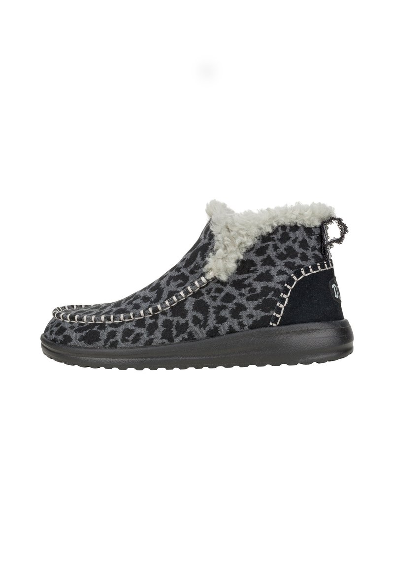 Stivaletto con stampa leopardata nera e grigia, foderato con morbido peluche bianco, cuciture a contrasto e suola nera texturizzata.