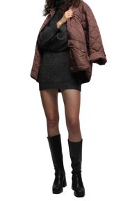 Brown quilted jacket, dark grey knitted dress, and black knee-high heeled boots. Focus on modern materials and sleek design.