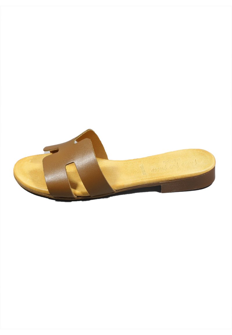 Sandalo scivoloso in pelle marrone con due ampie cinghie e una soletta sagomata. Suola piatta con una soletta beige e un sottile dettaglio di branding.