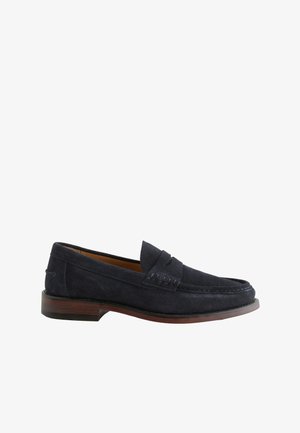 Mocassin en daim bleu marine pour homme avec semelle marron et coutures mocassin, style slip-on avec détail bande penny.