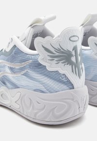 Des chaussures de sport avec un dessus texturé bleu et blanc orné de motifs en vagues, un accent de talon blanc moulé et une semelle blanche à motifs.