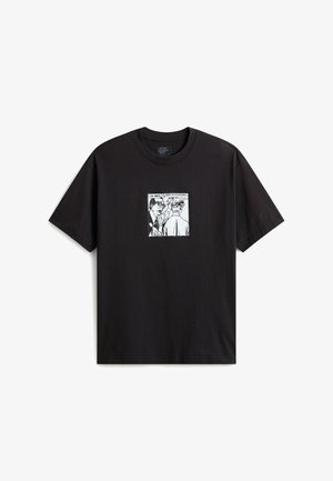 T-shirt nera a maniche corte con una grafica bianca in stile fumetto di due uomini, uno che tocca la testa dell’altro con una nuvoletta.